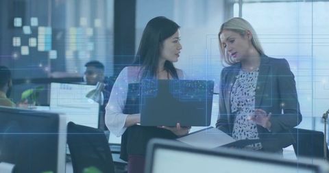 Two Businesswomen Collaborate in Technology-Driven Office Environment