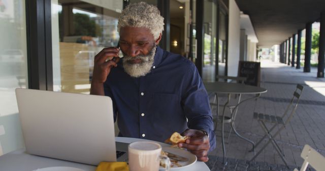 Senior Man Working Remotely at Outdoor Cafe with Laptop and Phone - Download Free Stock Images Pikwizard.com