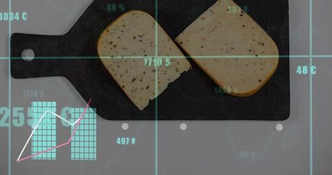 Displaying herbed cheese slices on dark cutting board with cyan grid overlay, data chart