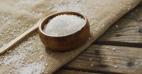 Coarse Sea Salt in Wooden Bowl on Rustic Wooden Table