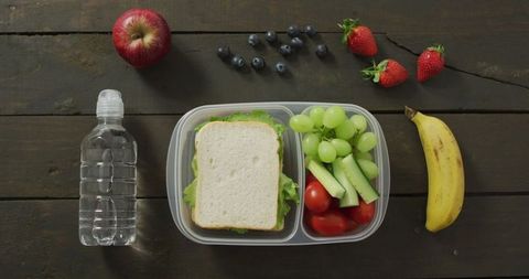 Healthy Packed Lunch with Fruits and Vegetables on Rustic Table