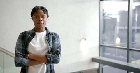 Confident Young Man in Modern Office Environment with Arms Crossed - Download Free Stock Images Pikwizard.com