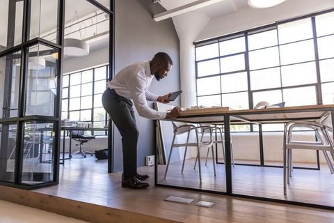 Professional Using Tablet for Design in Modern Loft Office