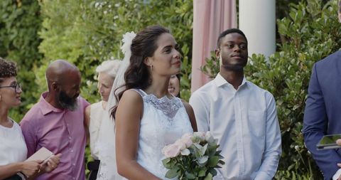 Bride smiling with groom during scenic outdoor wedding ceremony