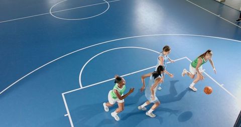 Diverse Female Athletes Playing Basketball on Indoor Court