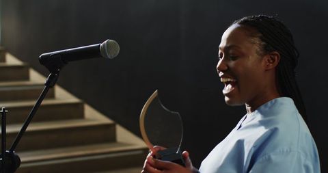 Woman celebrating achievement with award at ceremony