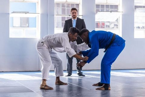 Martial Arts Grappling in Dojo with Attentive Referee