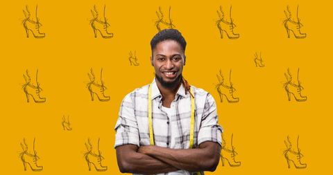 Confident fashion designer against shoe sketch pattern on orange background