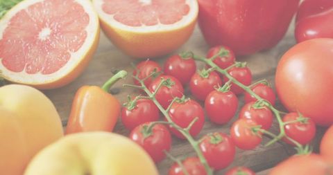 Colorful fresh produce flatlay showcasing cherry tomatoes, grapefruit, peppers, peaches