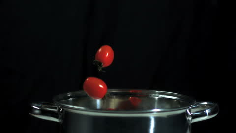 Chili and Tomatoes Dropping in Pot with Dramatic Splash