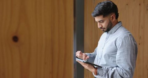 Young Professional Using Tablet in Modern Corridor