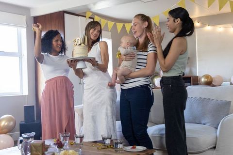 Diverse women celebrating together with cake and balloons