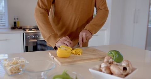 Slicing yellow bell pepper in modern kitchen for healthy home cooking