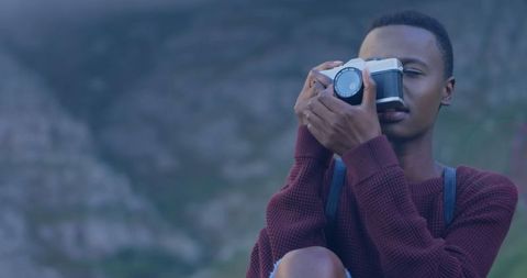 Young Photographer Capturing Nature with Film Camera Outdoors