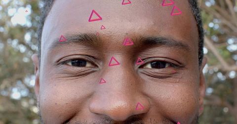 Smiling middle-aged black man closeup with magenta triangular overlay outdoors portrait