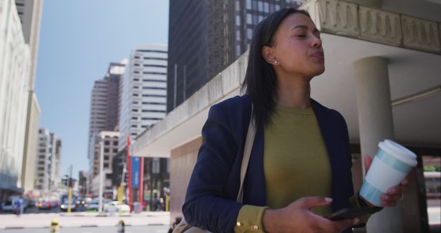 Businesswoman Walking in City Holding Coffee and Smartphone - Download Free Stock Images Pikwizard.com