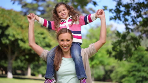 Joyful Mother and Daughter Embracing Nature in Lush Park