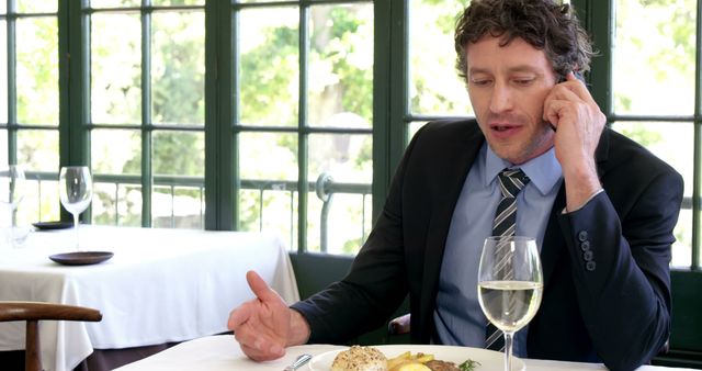 Businessman Having Lunch in Restaurant While Talking on Phone - Download Free Stock Images Pikwizard.com