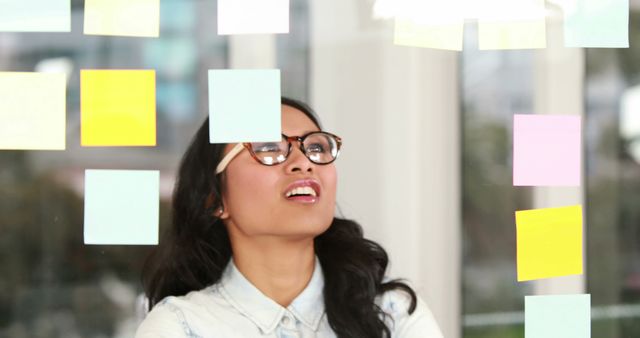 Businesswoman Brainstorming with Colorful Sticky Notes in Contemporary Office - Download Free Stock Images Pikwizard.com