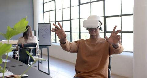 Man Exploring Virtual Reality with VR Headset in Modern Office