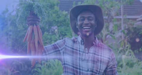 Smiling Gardener Holding Fresh Carrots in Community Garden