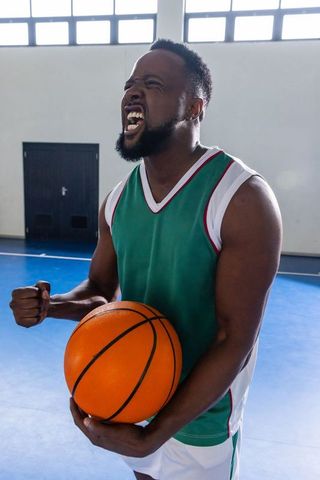 Energetic Basketball Player in Green Jersey on Indoor Court
