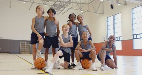 Diverse Youth Basketball Team Posing Joyfully in Gymnasium
