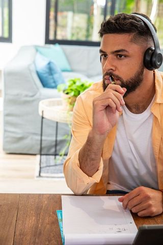 Focused Man Using Headphones for Deep Work in Cozy Home Office