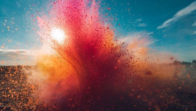 Vibrant Eruption of Red and Orange Powder Over Water at Dusk