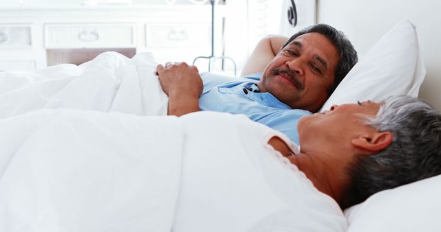 Senior Couple Relaxing in Bed Smiling At Each Other - Download Free Stock Images Pikwizard.com