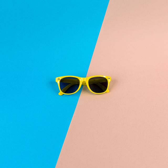 Yellow Sunglasses on Vibrant Blue and Beige Background - Download Free Stock Photos Pikwizard.com