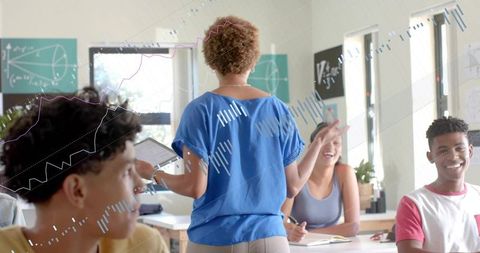 Instructor leading interactive math lesson with tablet, engaging students in bright classroom