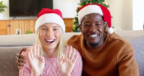 Diverse Couple Wearing Santa Hats Greeting During Festive Season