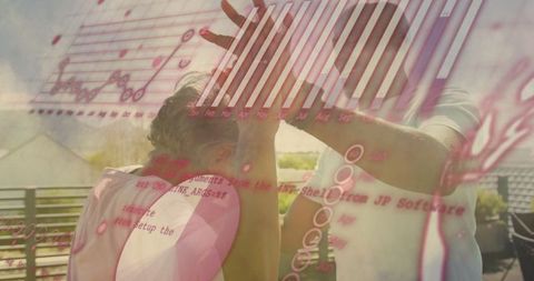 Senior woman and mature man celebrate success with high-five on rooftop