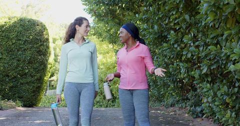 Diverse Female Friends Walking with Reusable Water Bottles Outdoors