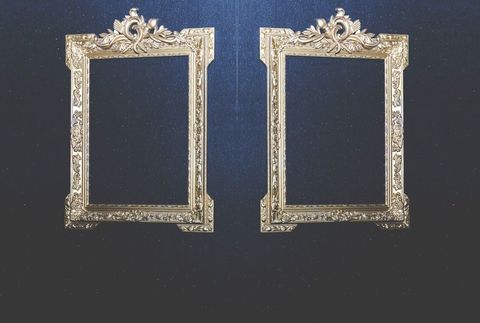 Elegant ornate gold frames against dark textured wall