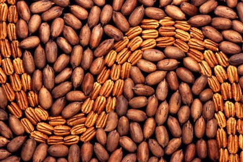 Artistic arrangement of whole and shelled pecans creating unique pattern