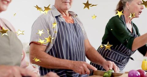 Seniors chopping vegetables in cooking workshop with gold star overlay promoting teamwork
