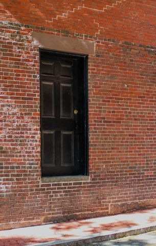 Mysterious black door in brick wall background