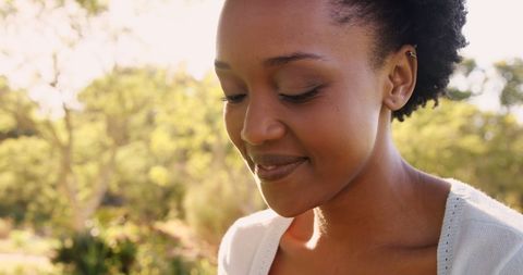 Smiling Woman Enjoying Outdoor Park Setting with Smartphone