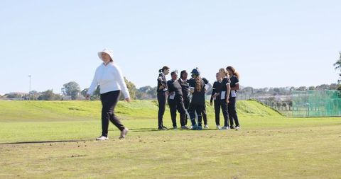 Group of female golf players gathering on grass field