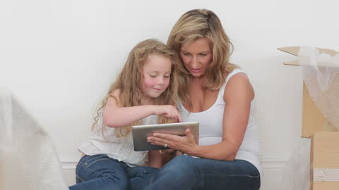 Mother and Daughter Bonding While Using Tablet at Home
