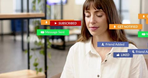 Young woman receiving social media notifications while working in modern coworking space
