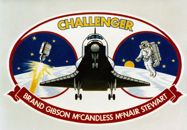 The Space Shuttle Challenger, making its fourth space flight, highlights the 41B insignia. The reusable vehicle is flanked in the oval by an illustration of a Payload Assist Module-D  solid rocket motor (PAM-D) for assisted satellite deployment; an astronaut making the first non-tethered extravehicular activity (EVA); and eleven stars. 