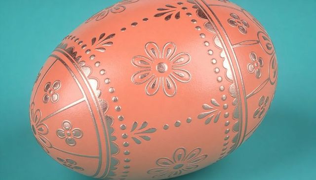 Ornate metallic floral easter egg close-up on teal background