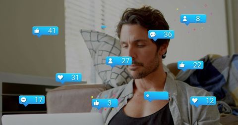 Mid-adult man using laptop with floating social media notifications, digital engagement scene