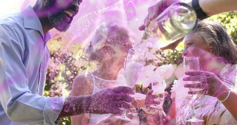Toasting friends raising champagne flutes in sunlit backyard celebration