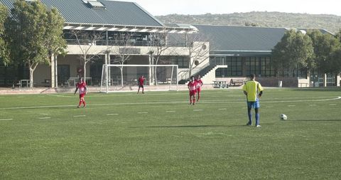 Youth soccer players preparing penalty kick at school field