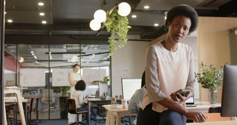 Confident Businesswoman in Modern Office Using Smartphone