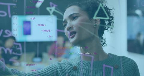Woman pointing at glass board explaining code and UX diagrams during tech collaboration